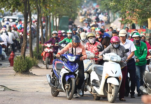 Bị cấm đường, người dân leo lên vỉa hè đường Lê Văn Lươngđi ngược chiều. Ảnh:Ngọc Thành.