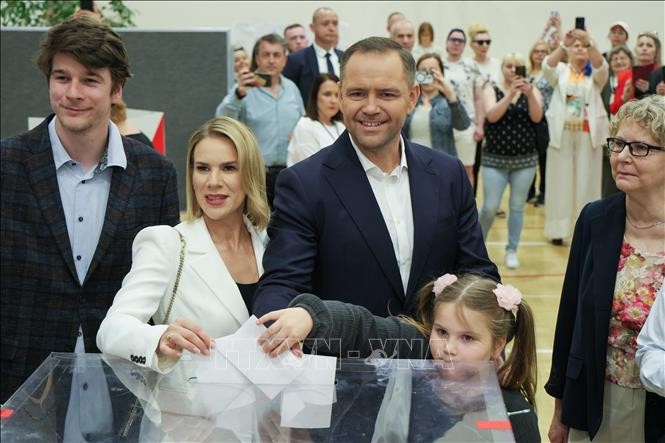 Ứng cử viên Tổng thống Ba Lan Karol Nawrocki (giữa) bỏ phiếu bầu Tổng thống vòng hai tại điểm bầu cử ở Vacsava, Ba Lan, ngày 1/6/2025. (Ảnh: PAP/TTXVN) 