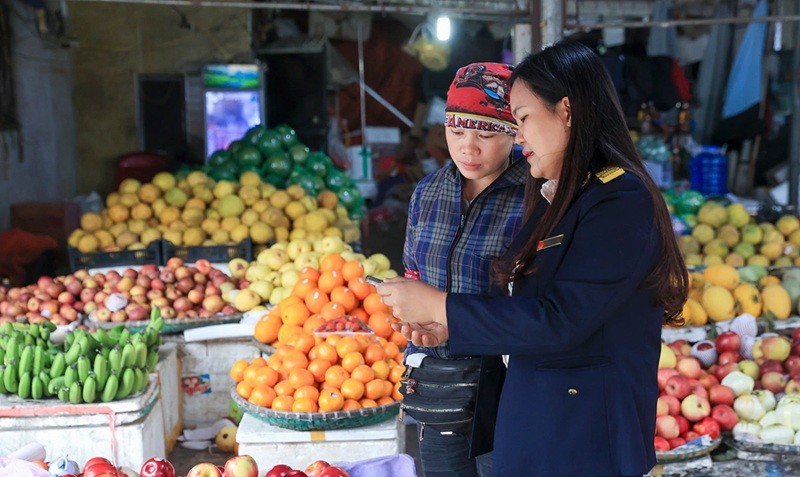 Công chức thuế hỗ trợ hộ kinh doanh thực hiện các thủ tục về thuế. Ảnh: Đức Thanh.