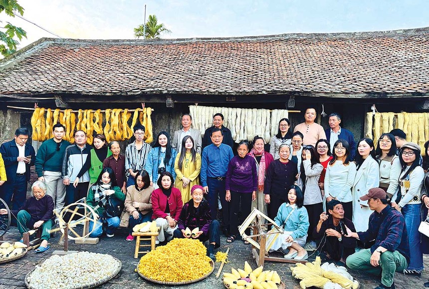 Các nghệ nhân trình diễn và hướng dẫn du khách trải nghiệm se tơ, rút đũi tại làng nghề dệt đũi Nam Cao (Ảnh: Hồ Hạ) 