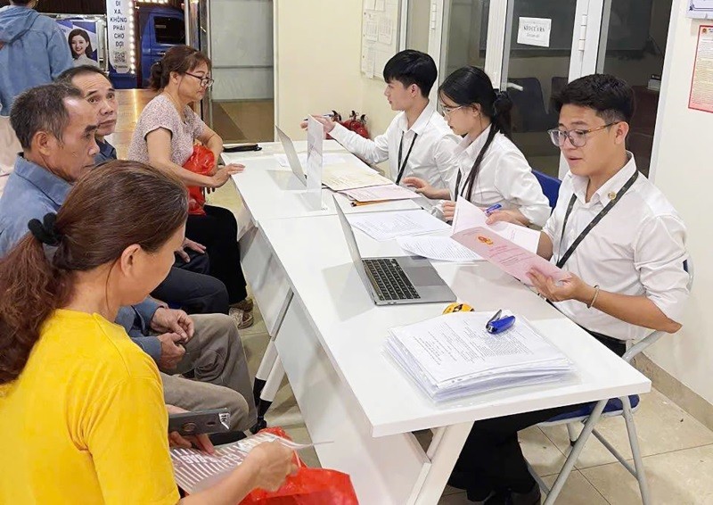 Cán bộ của Trung tâm phục vụ hành chính công Hà Nội hướng dẫn thủ tục cho người dân. Ảnh minh họa.