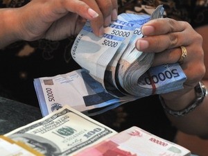 Đếm đồng rupiah Indonesia và đồng đôla Mỹ ở thủ đô Jakarta. (Ảnh: AFP/TTXVN)