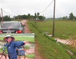 Một nông dân chỉ khu ruộng bị thu hồi để làm Dự án Trang trại
